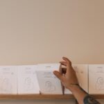 barista's hand reaching one of the boxes with coffee beans from the DAK roastery on a shelf