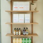 wooden shelf with decorations coffee beans lemonades kombuchas and oat and pea milks