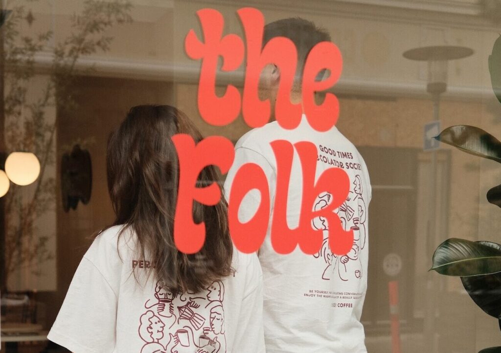 coffee shop owners behind a glass wall with the logo