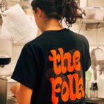 kitchen staff from back in the kitchen wearing the folk merchandise