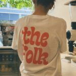 barista from back behind the bar wearing the folk merchandise